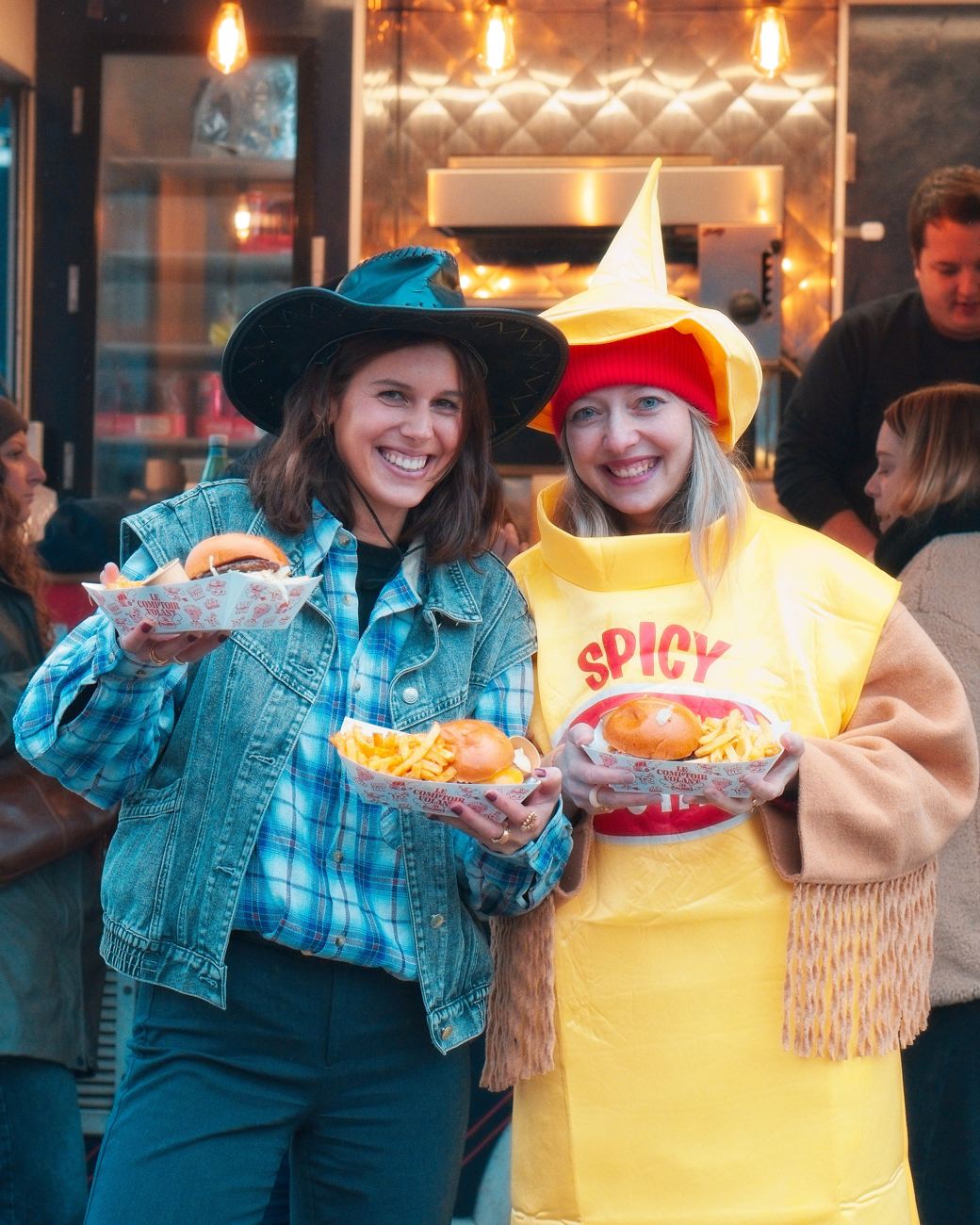 Deux collaboratrices déguisées, burger et frites en main