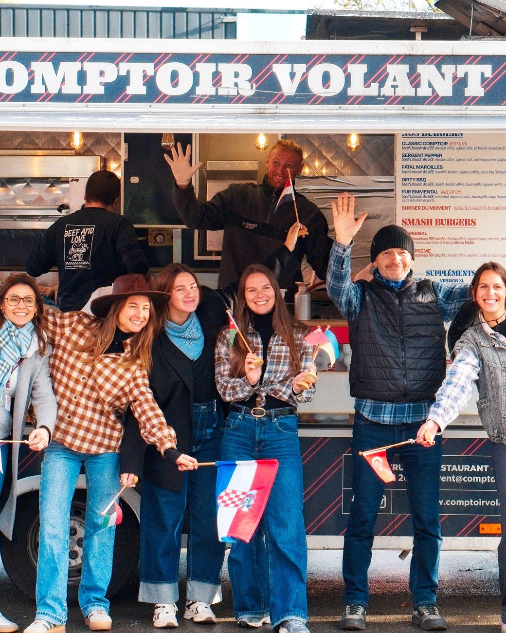 L’équipe de Tape à l’œil devant le food truck, drapeaux à la main